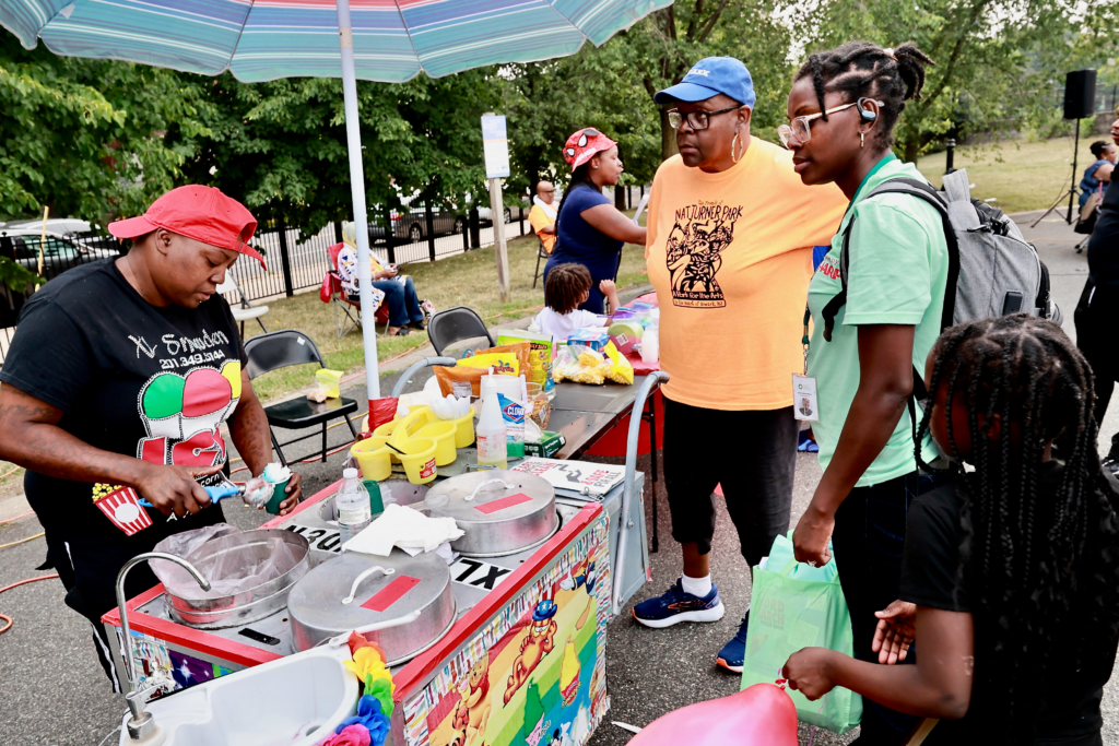 Community members gather around a food vendor during National Night Out at Nat Turner Park in Newark
