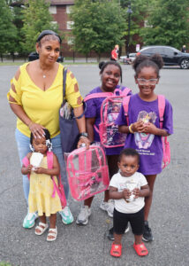 Family posing with backpacks during National Night Out at Nat Turner Park