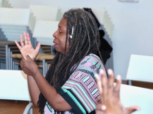Yoga instructor leading a seated arm stretch during a senior yoga session at Grace Manor