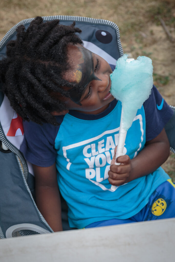 Child enjoying cotton candy at a Jesse Allen Park community event