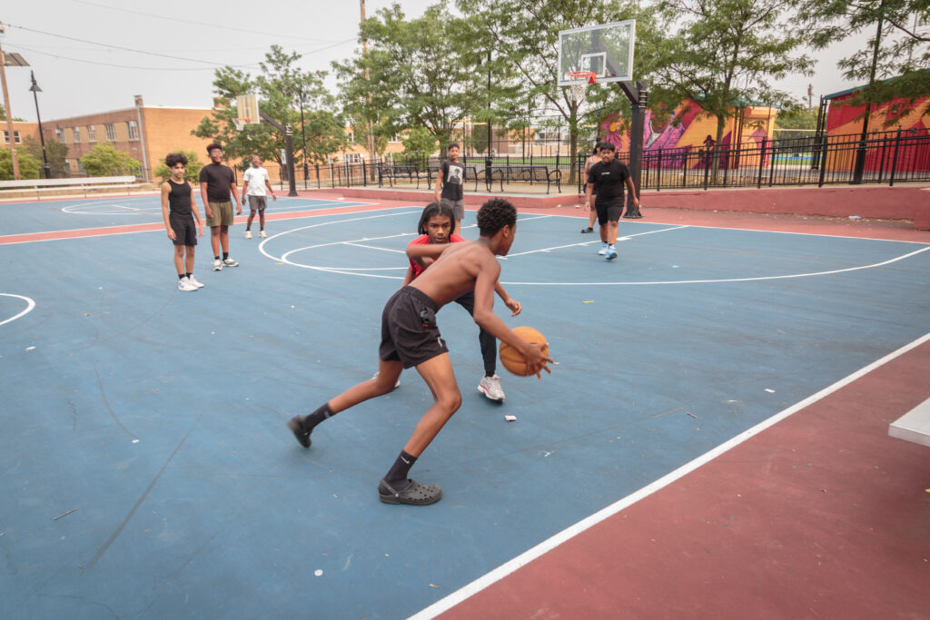 Youth playing basketball on outdoor courts at Jesse Allen Park