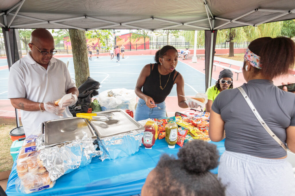 Volunteers serving food at a Jesse Allen Park community event