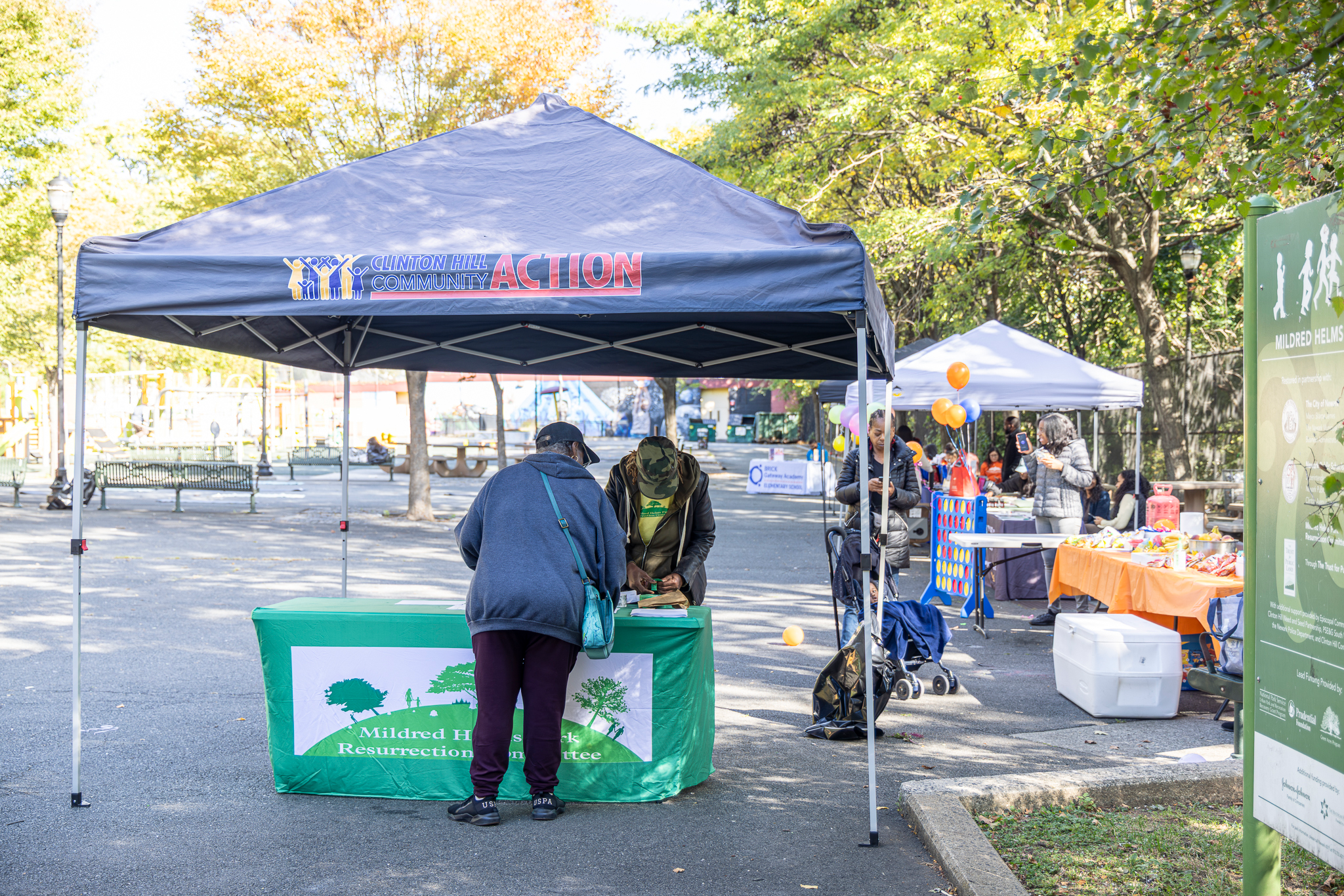 Community members visiting a resource table at Mildred Helms Park during the Health & Resources Fair.