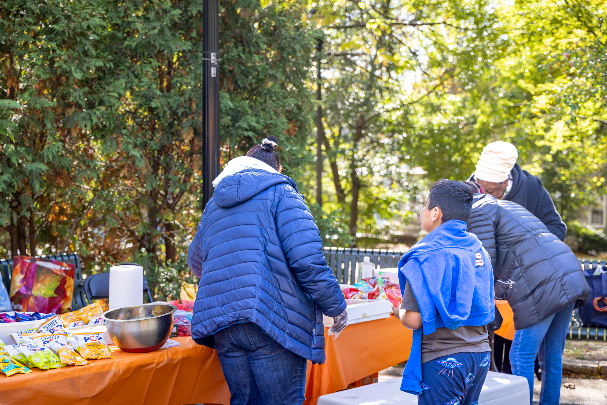 Families visiting a snack and activity table at the Health & Resources Fair in Mildred Helms Park.