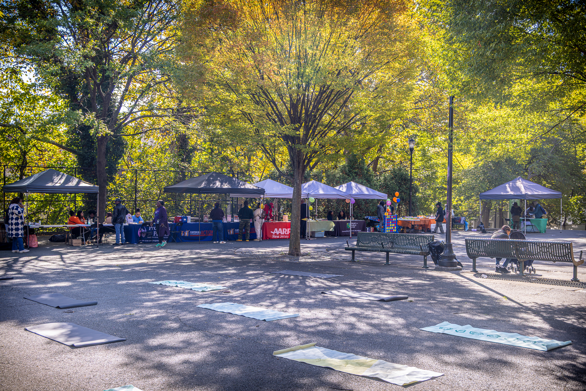 Wellness mats laid out in Mildred Helms Park with community resource tents in the background.